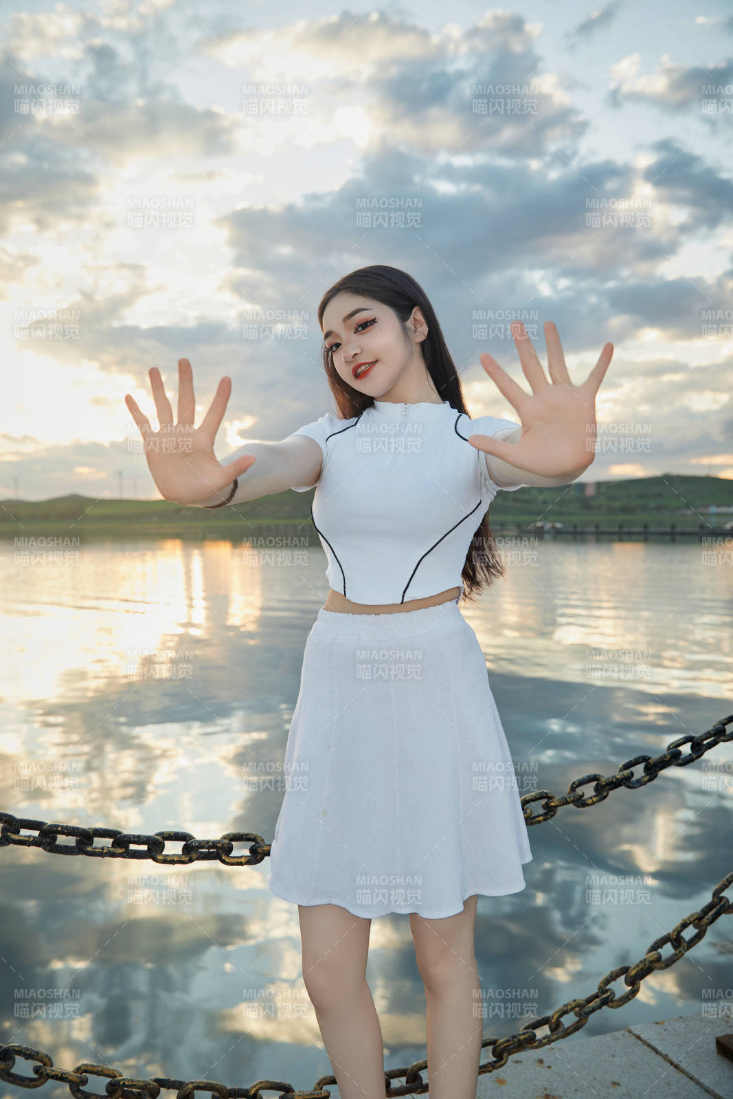 傍晚在湖邊欣賞風景拍照的亞洲美女