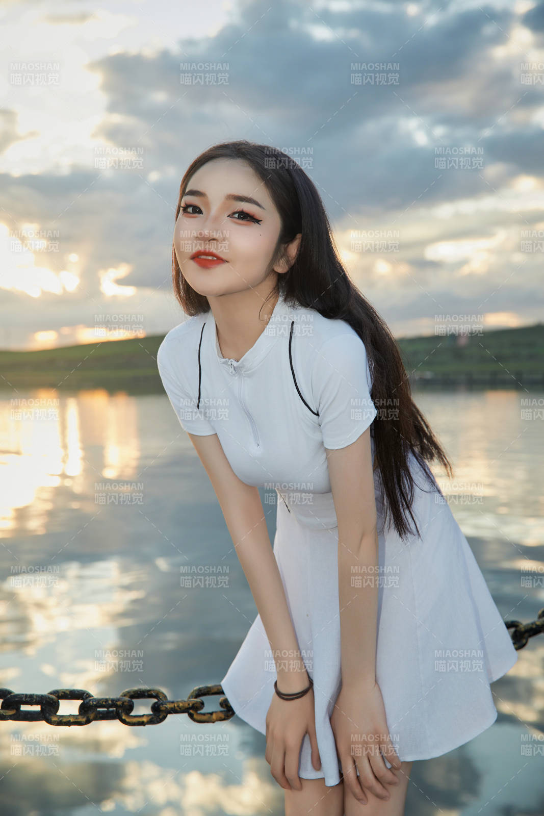 傍晚在湖邊欣賞風景拍照的亞洲美女