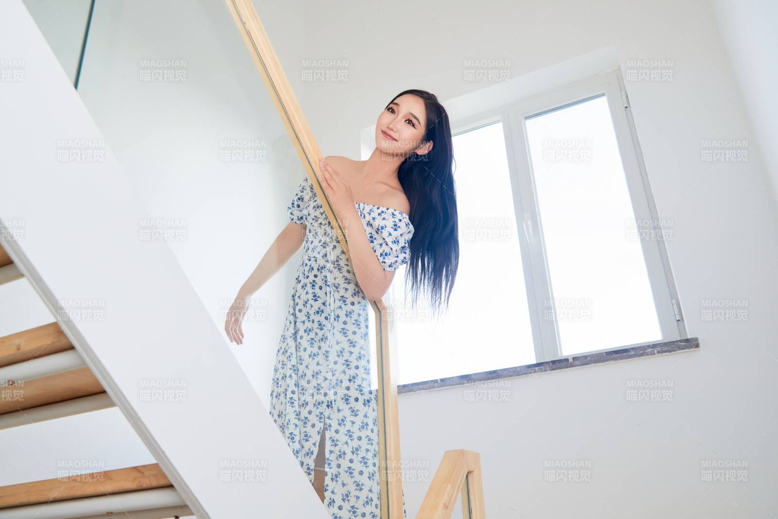在别墅内的楼梯上拍照的亚洲美女