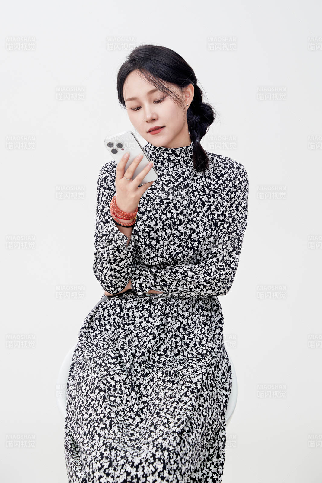 白色背景下使用手机的亚洲女性