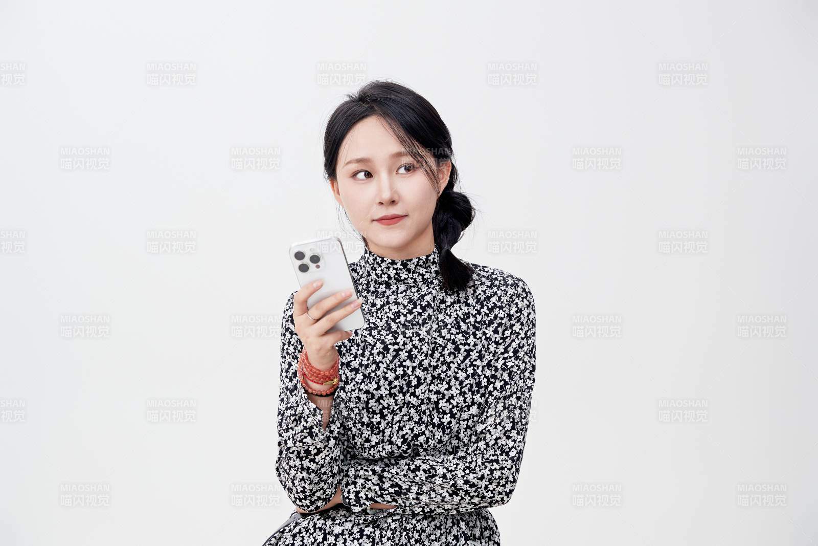 白色背景下使用手機(jī)的亞洲女性