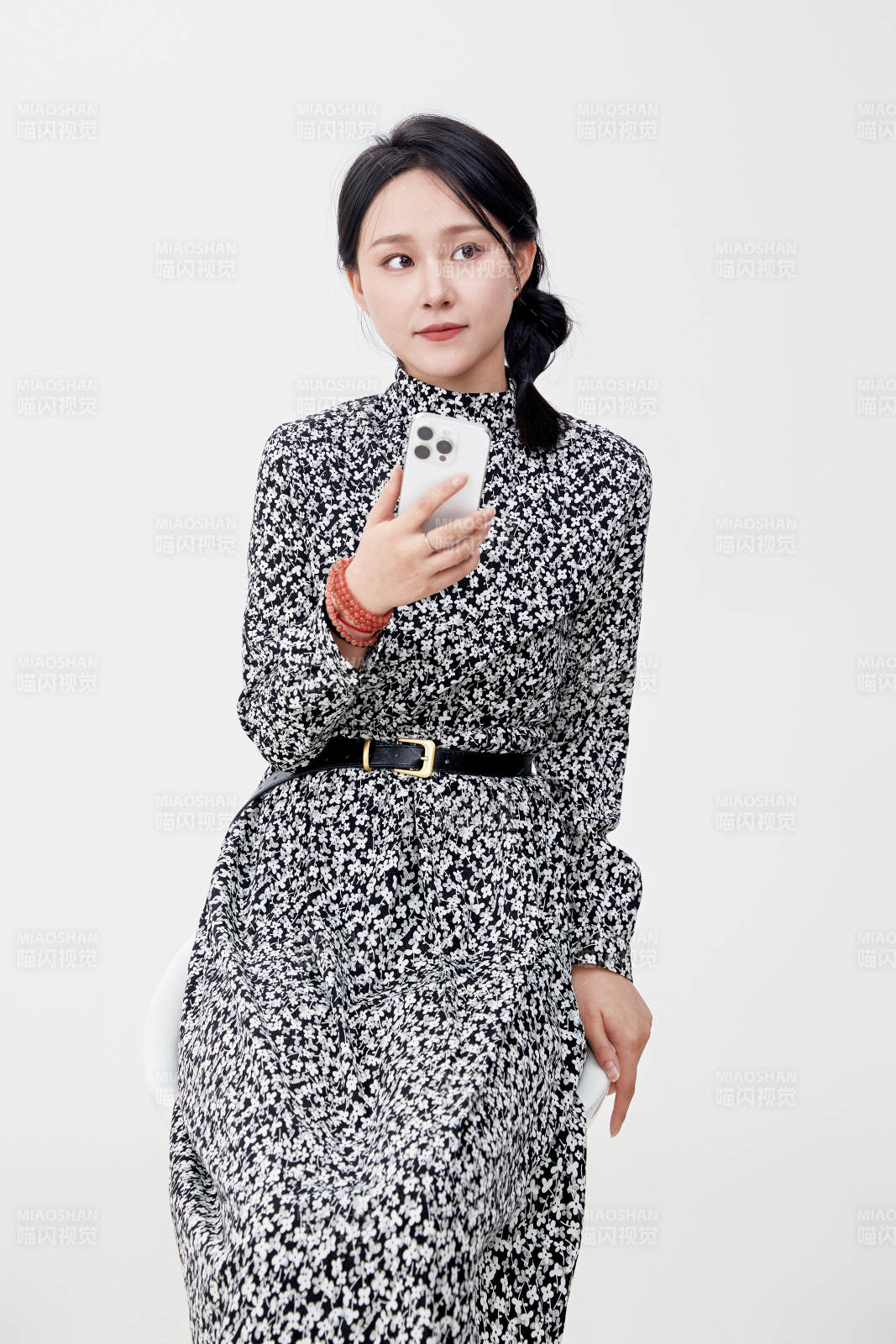 白色背景下使用手機(jī)的亞洲女性