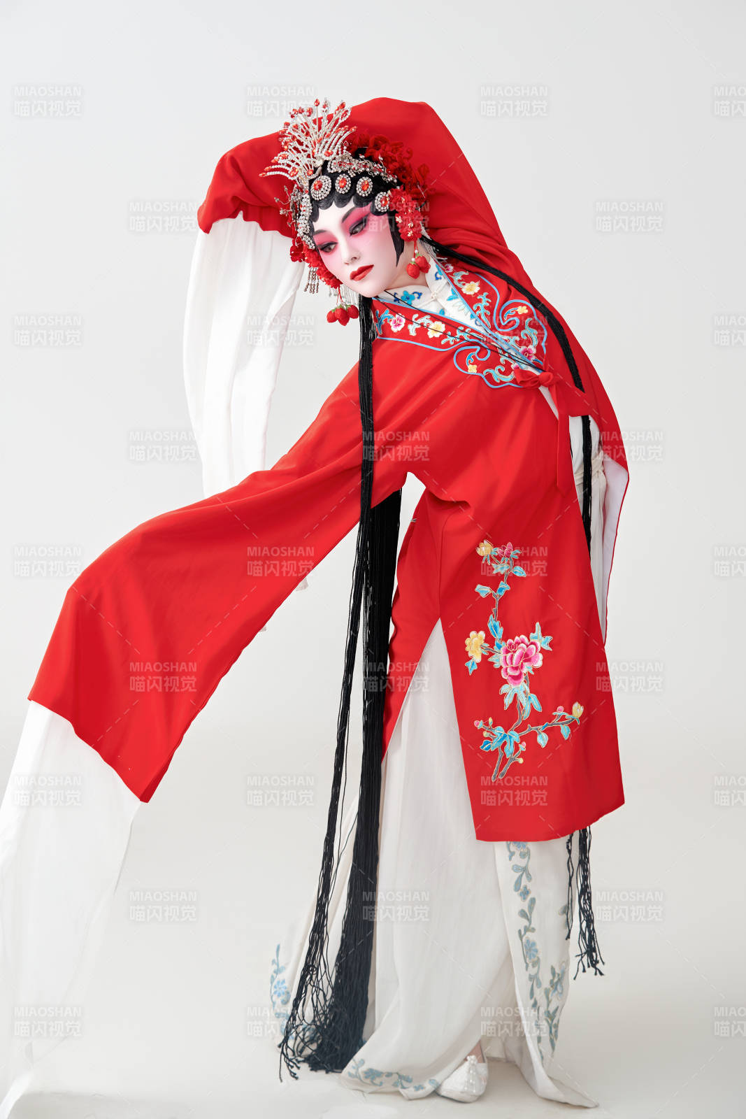 表演中國(guó)國(guó)粹京劇動(dòng)作的紅衣花旦女性演員