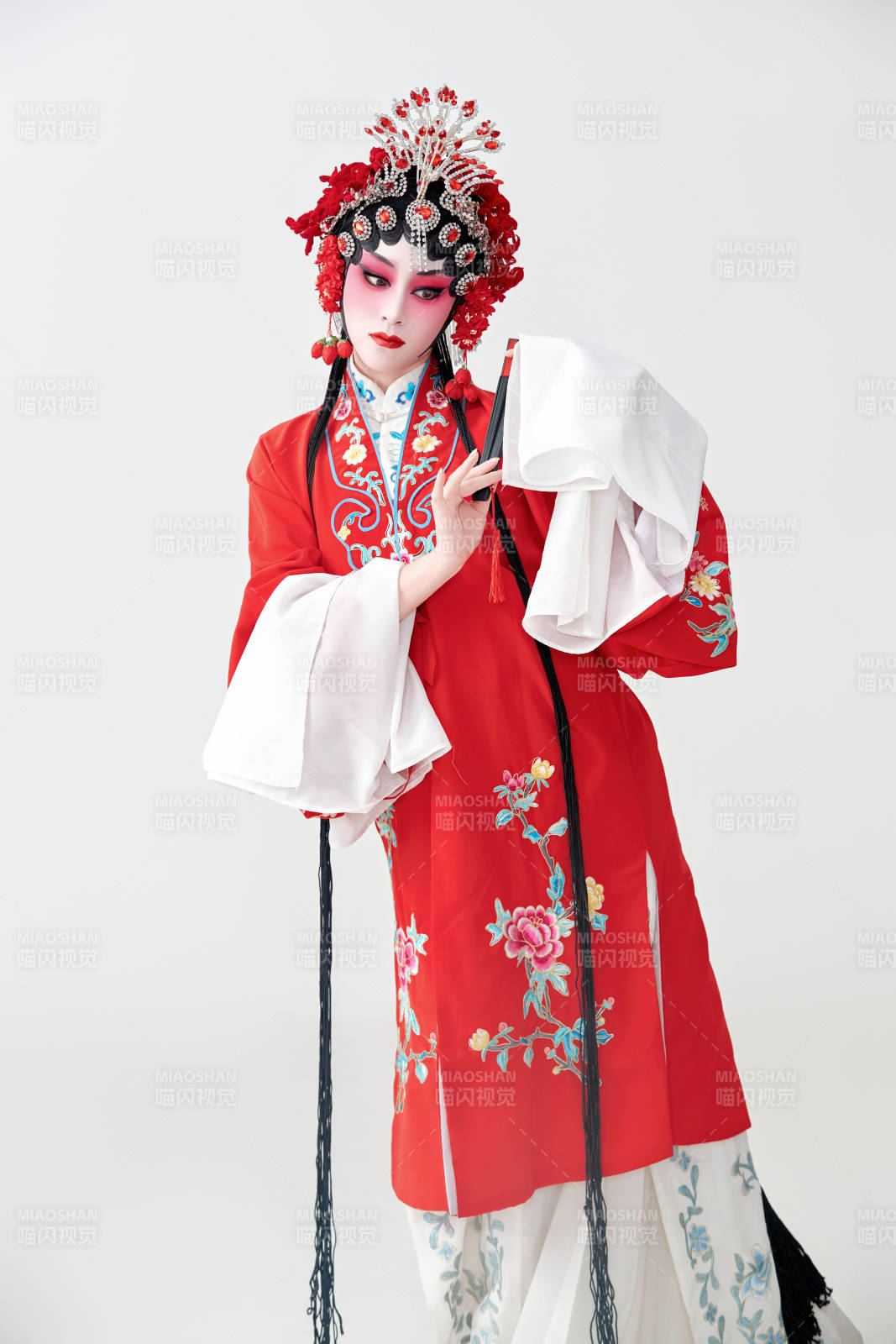 表演中國(guó)國(guó)粹京劇動(dòng)作的紅衣花旦女性演員