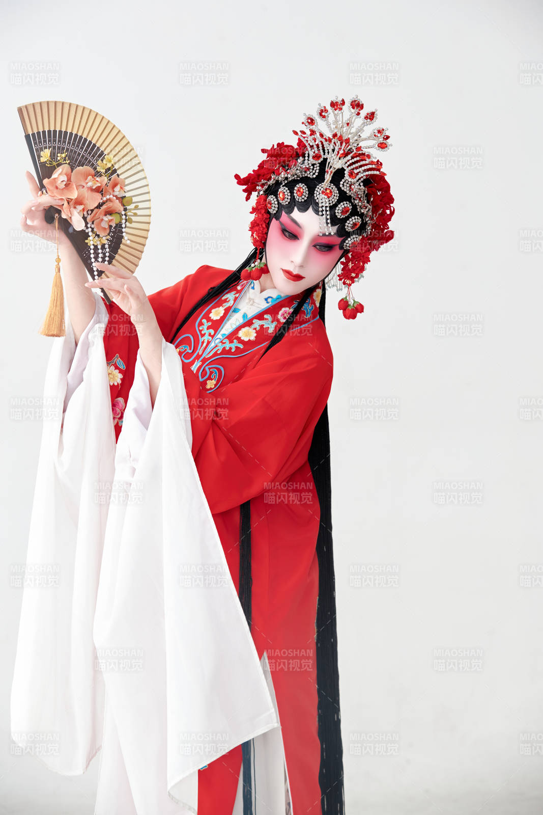 表演中國國粹京劇動作的紅衣花旦女性演員