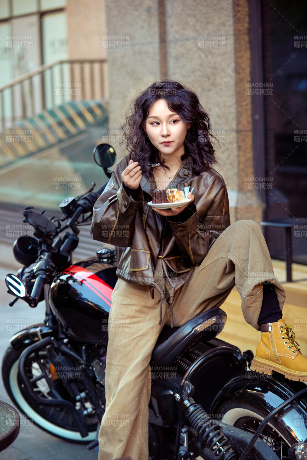 户外在复古机车上品尝甜点的亚洲美女