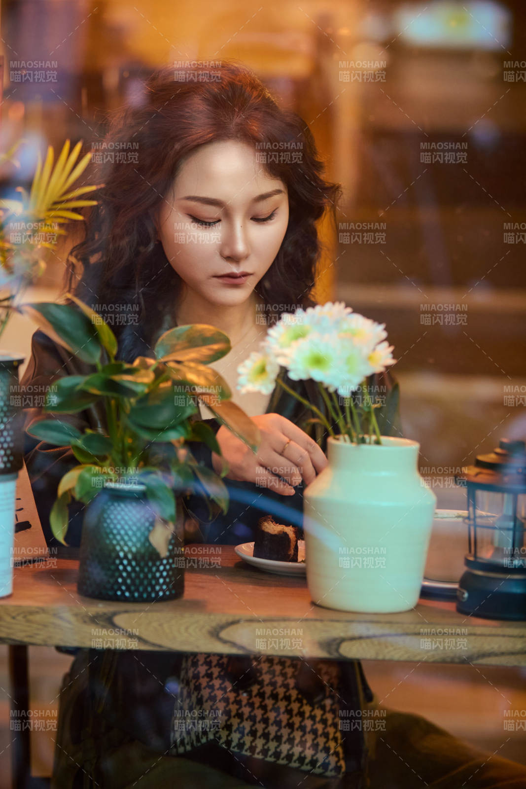 傍晚坐在咖啡店里享受咖啡蛋糕的美女