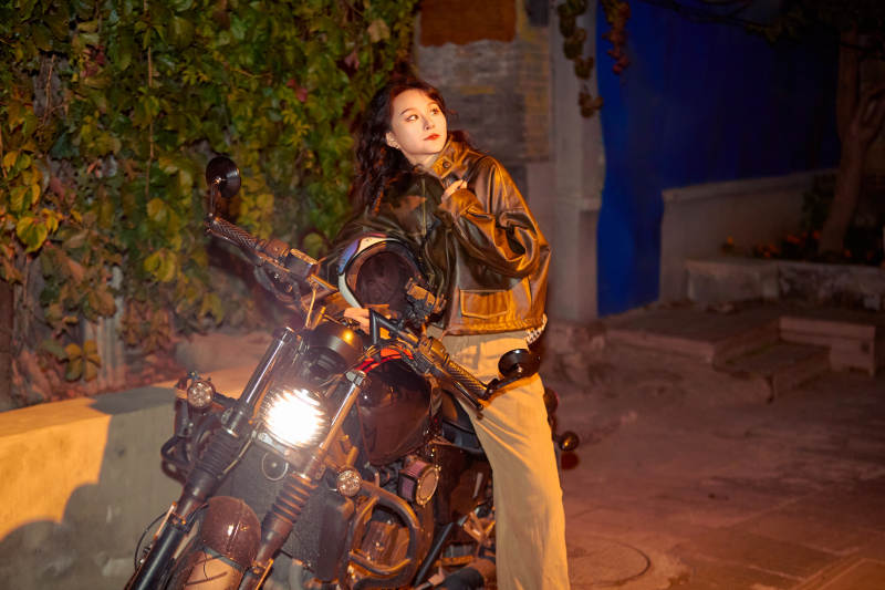 夜色下骑复古摩托车的亚洲美女