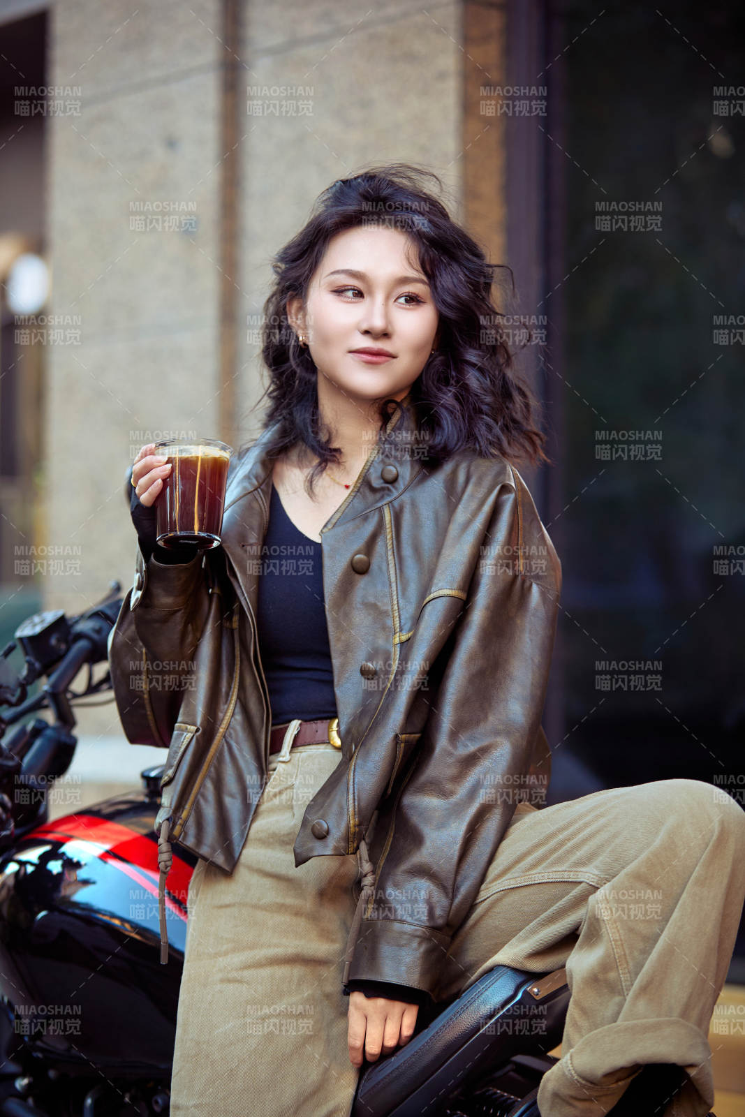 手拿冰美式咖啡坐在摩托上的亞洲美女