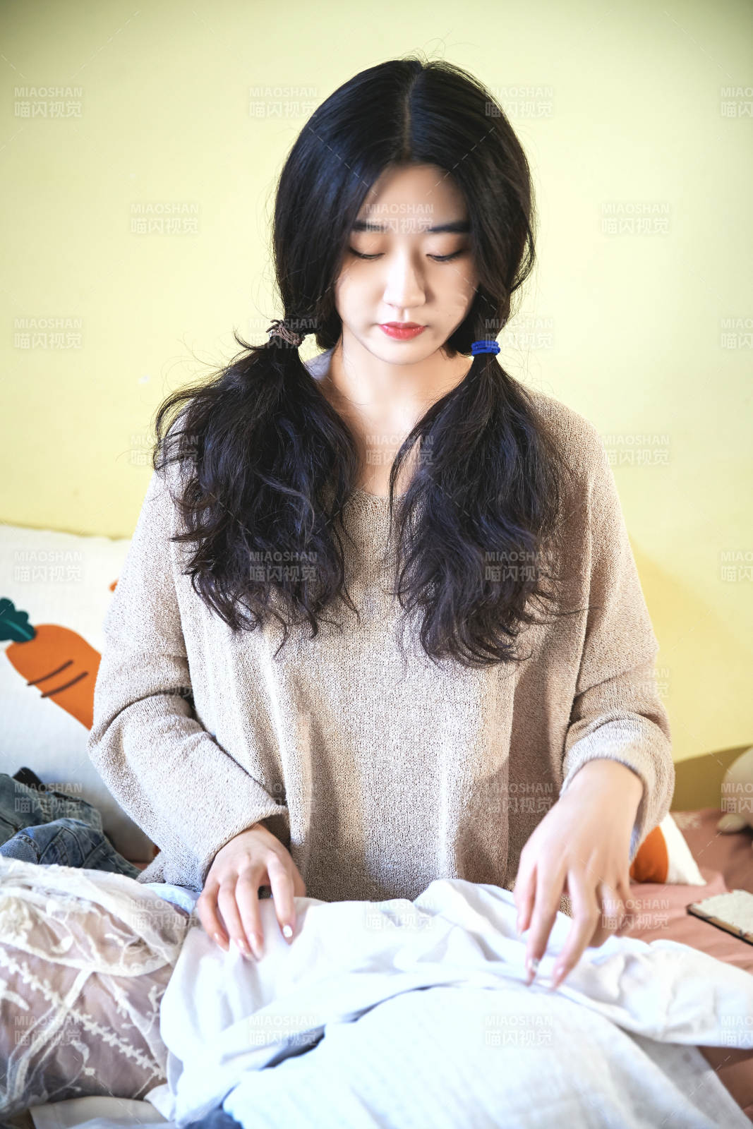 在沙發床上整理行裝的年輕亞洲女性