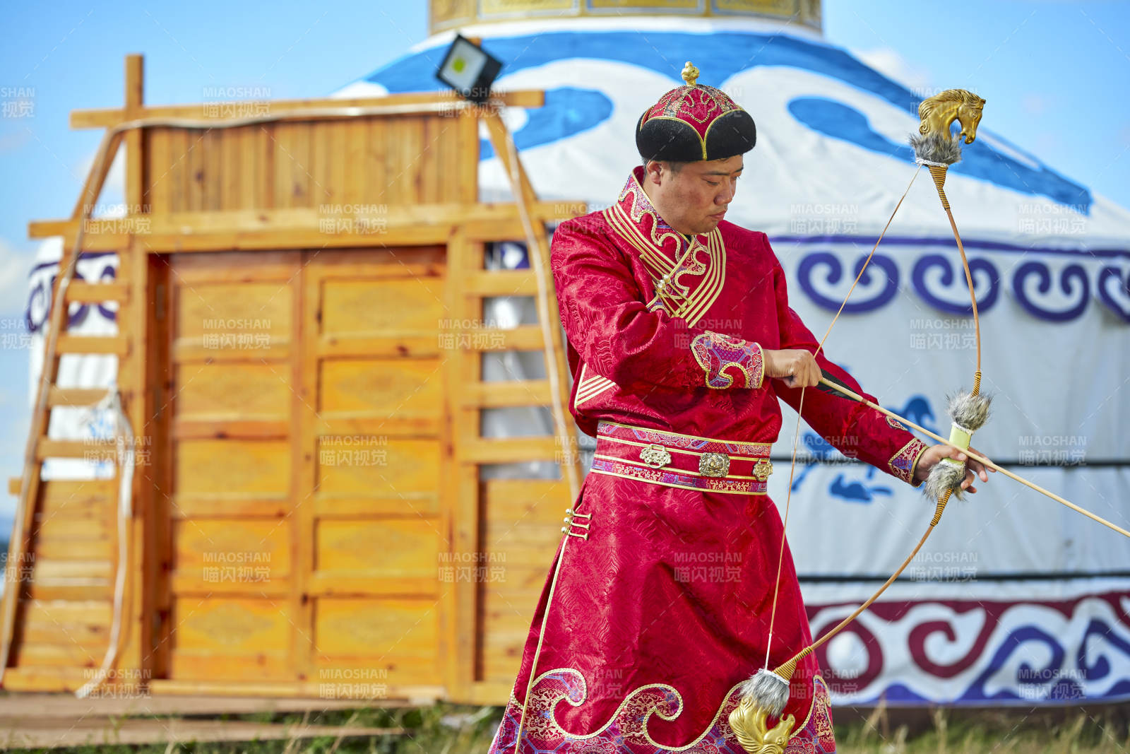 蒙古包前身穿蒙古族飾手持弓箭的蒙族漢子