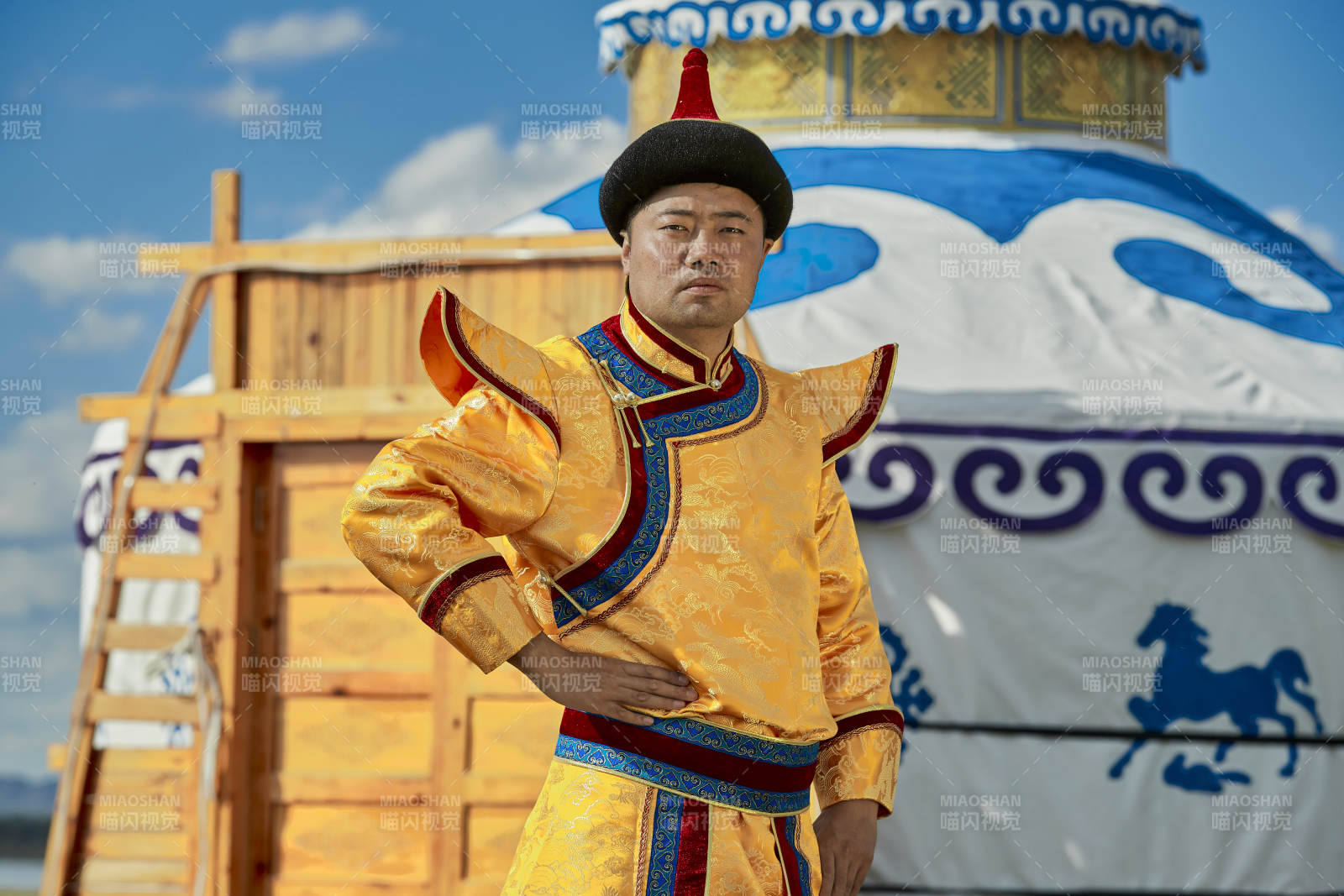 草原上蒙古包前身穿蒙古族傳統(tǒng)服飾的男子