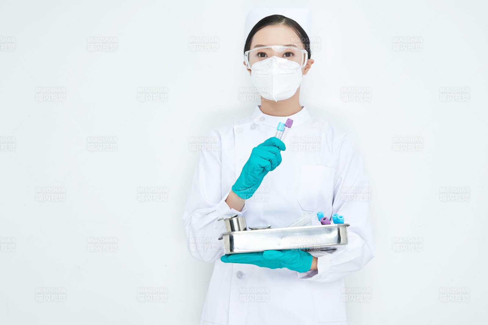 身穿護士服手抱化驗托盤的年輕女護士