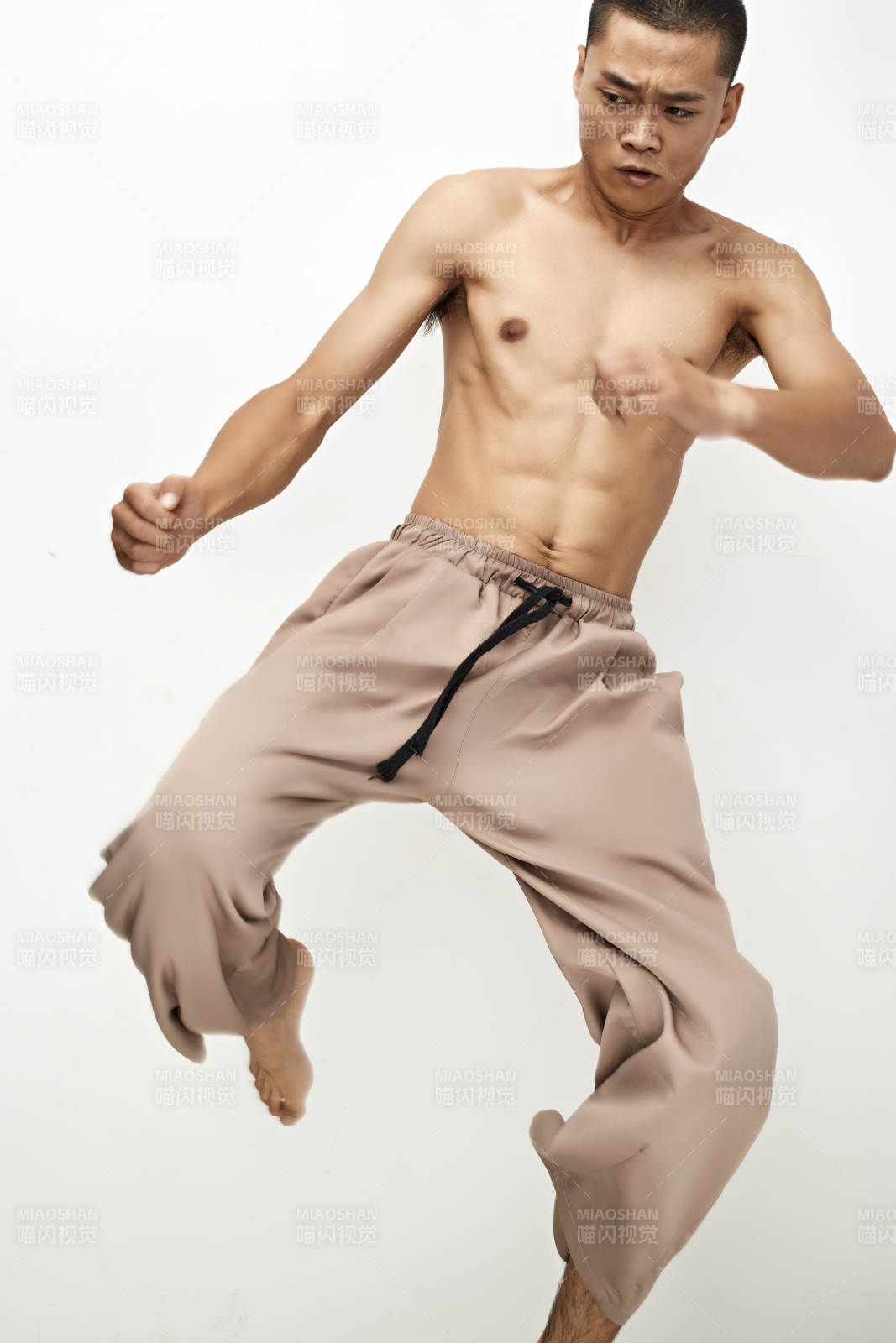 白色背景下演示自由搏擊動(dòng)作的亞洲功夫男性