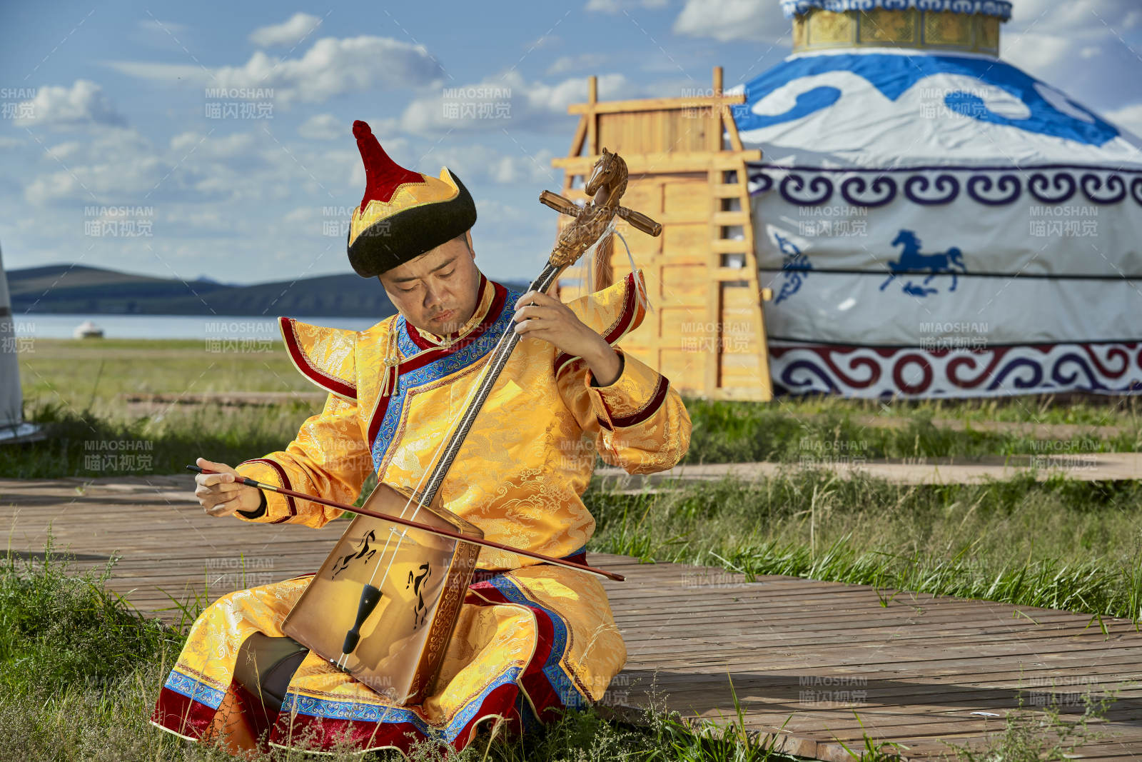蒙古包前身穿蒙古族服飾拉馬頭琴的男子
