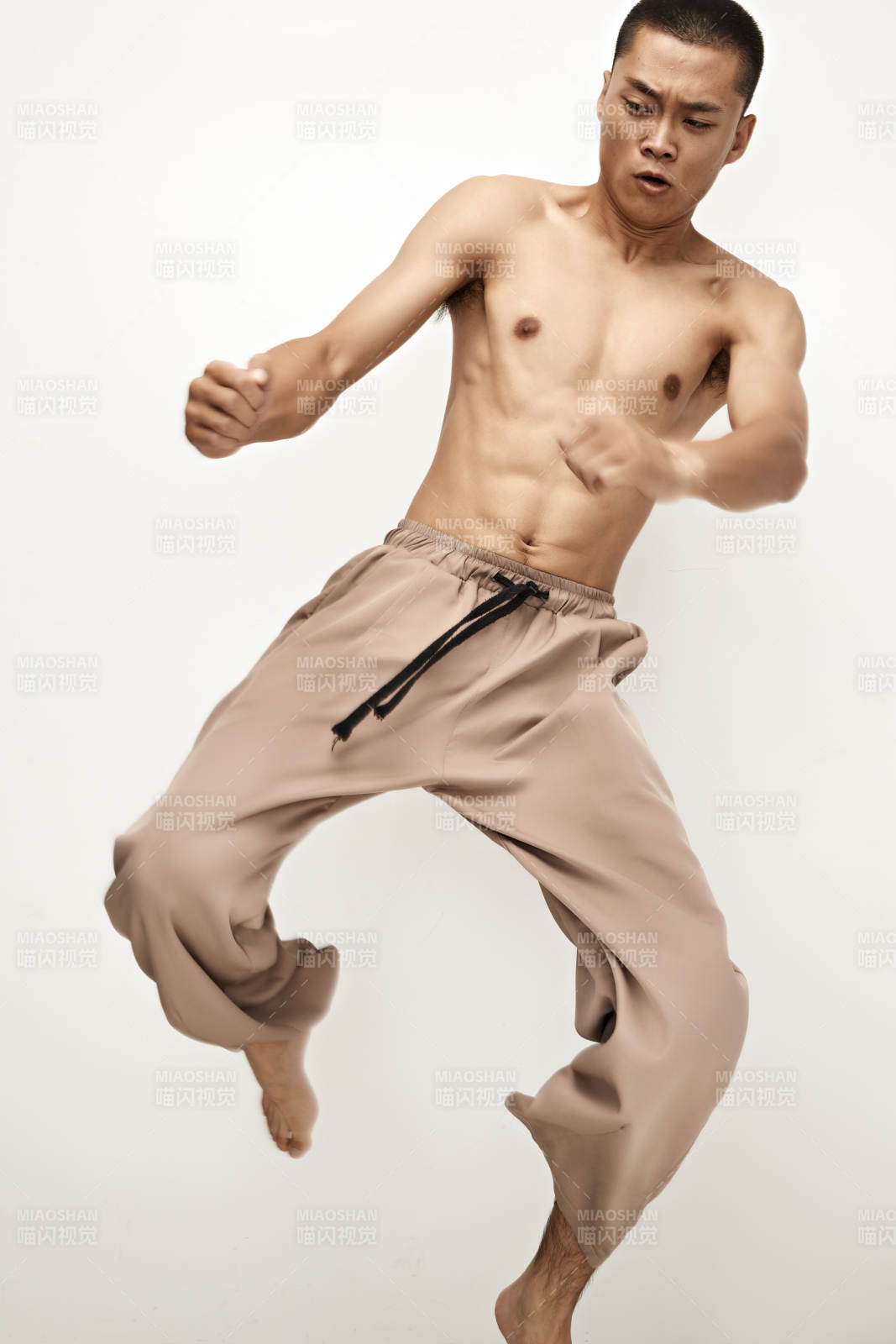 白色背景下演示自由搏擊動作的亞洲功夫男性