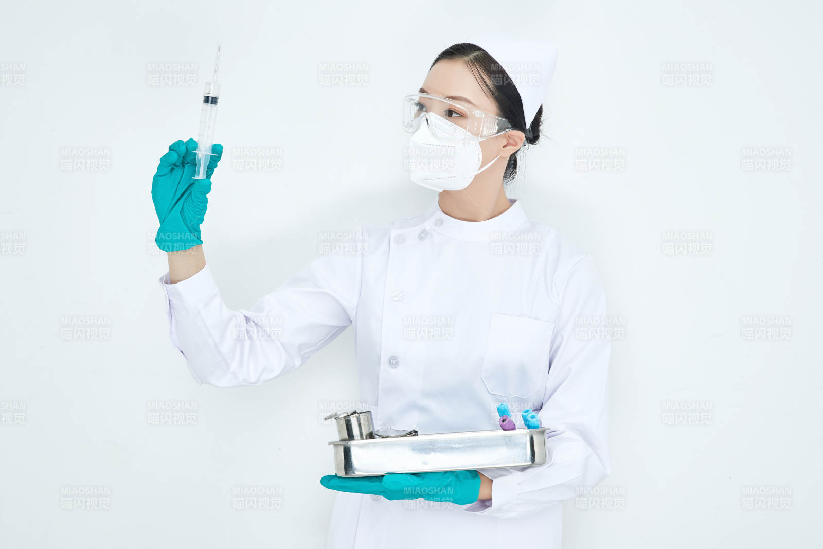 身穿護士服手抱化驗托盤的年輕女護士