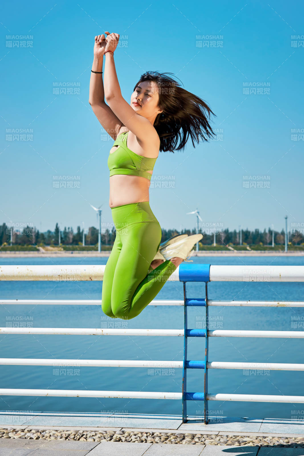 戶外河畔公園做拉伸有氧運(yùn)動(dòng)的亞洲女性