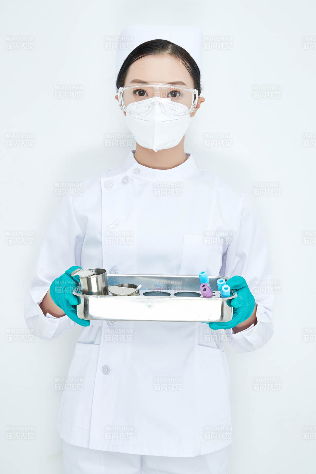 身穿護士服手抱化驗托盤的年輕女護士