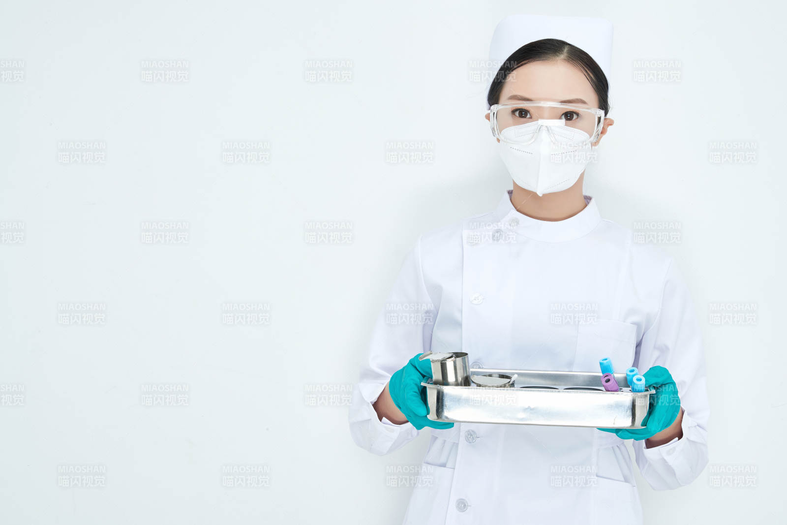 身穿護士服手抱化驗托盤的年輕女護士