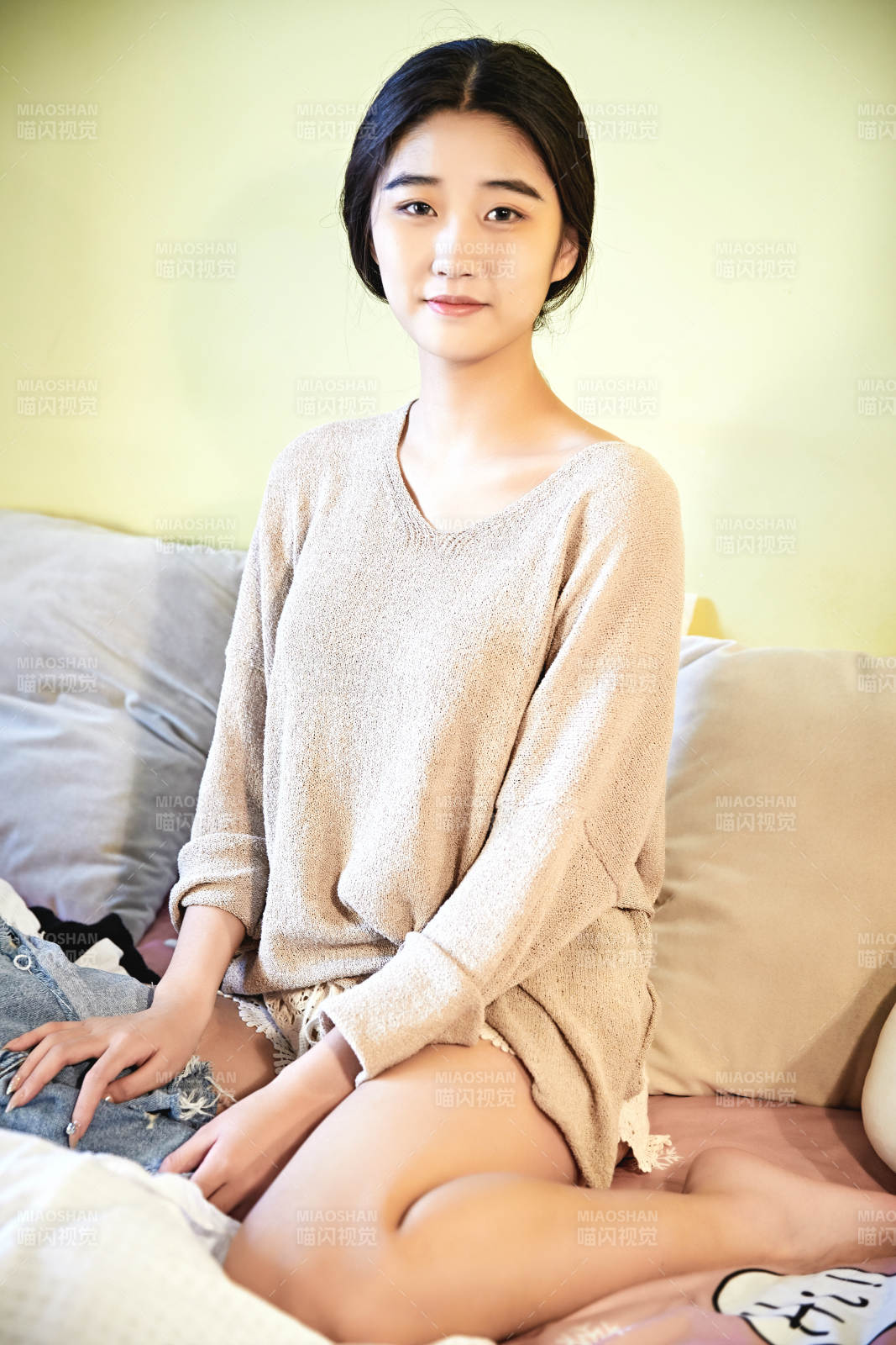 在沙發床上整理行裝的年輕亞洲女性