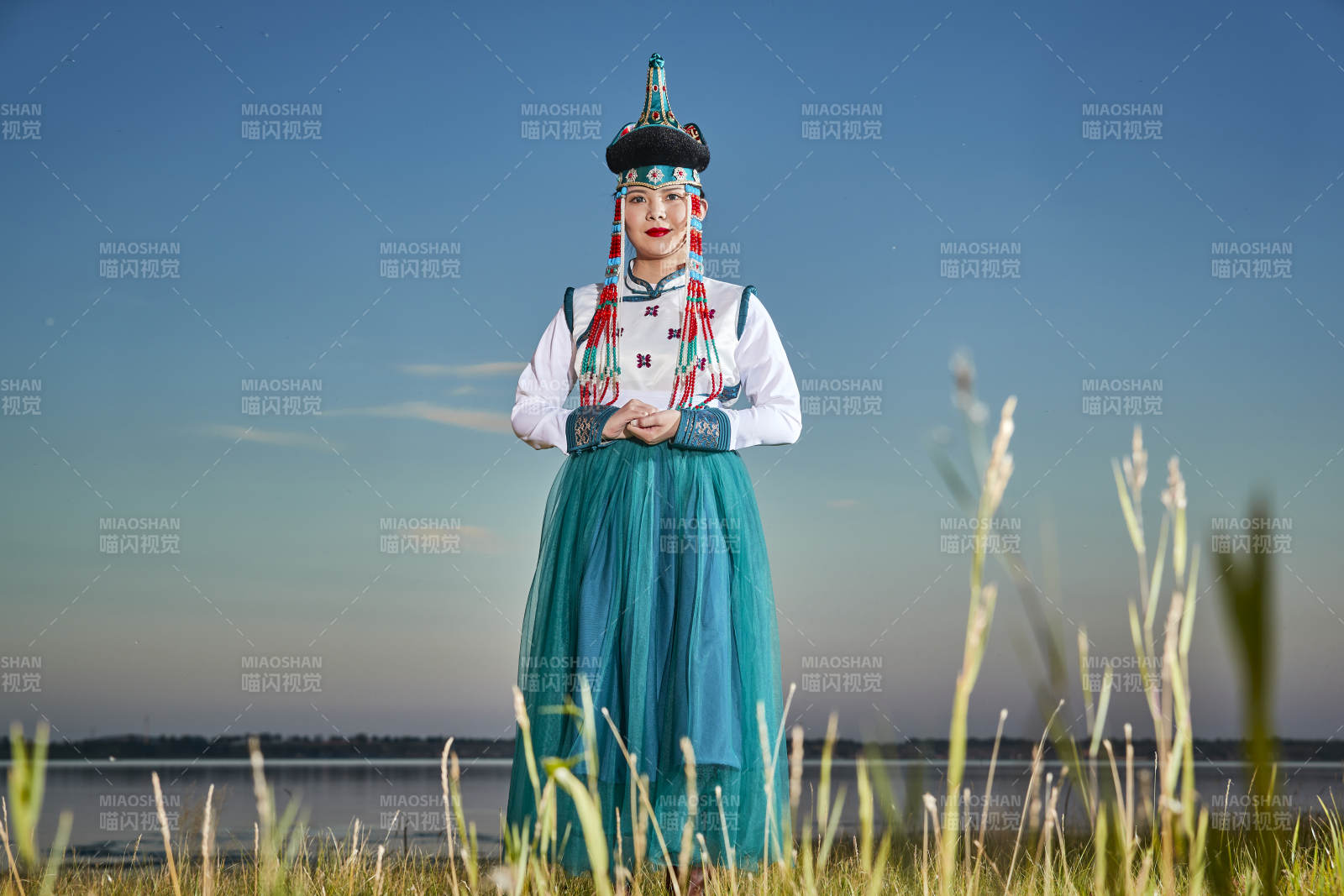 草原上穿著蒙古族傳統(tǒng)服飾的年輕蒙族姐妹