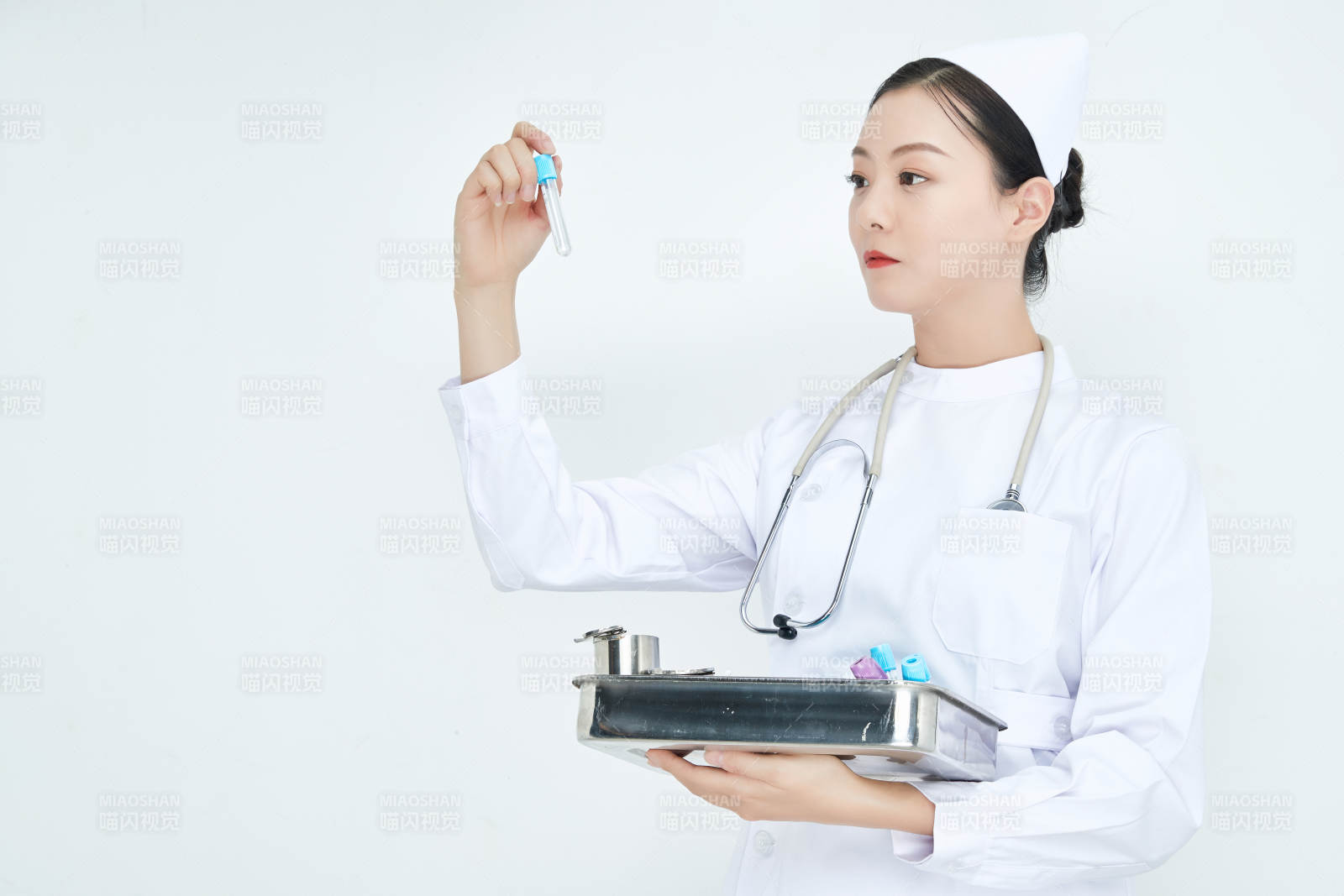 身穿護士服手抱化驗托盤的年輕女護士
