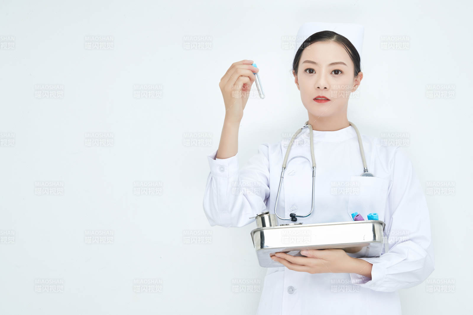 身穿護士服手抱化驗托盤的年輕女護士