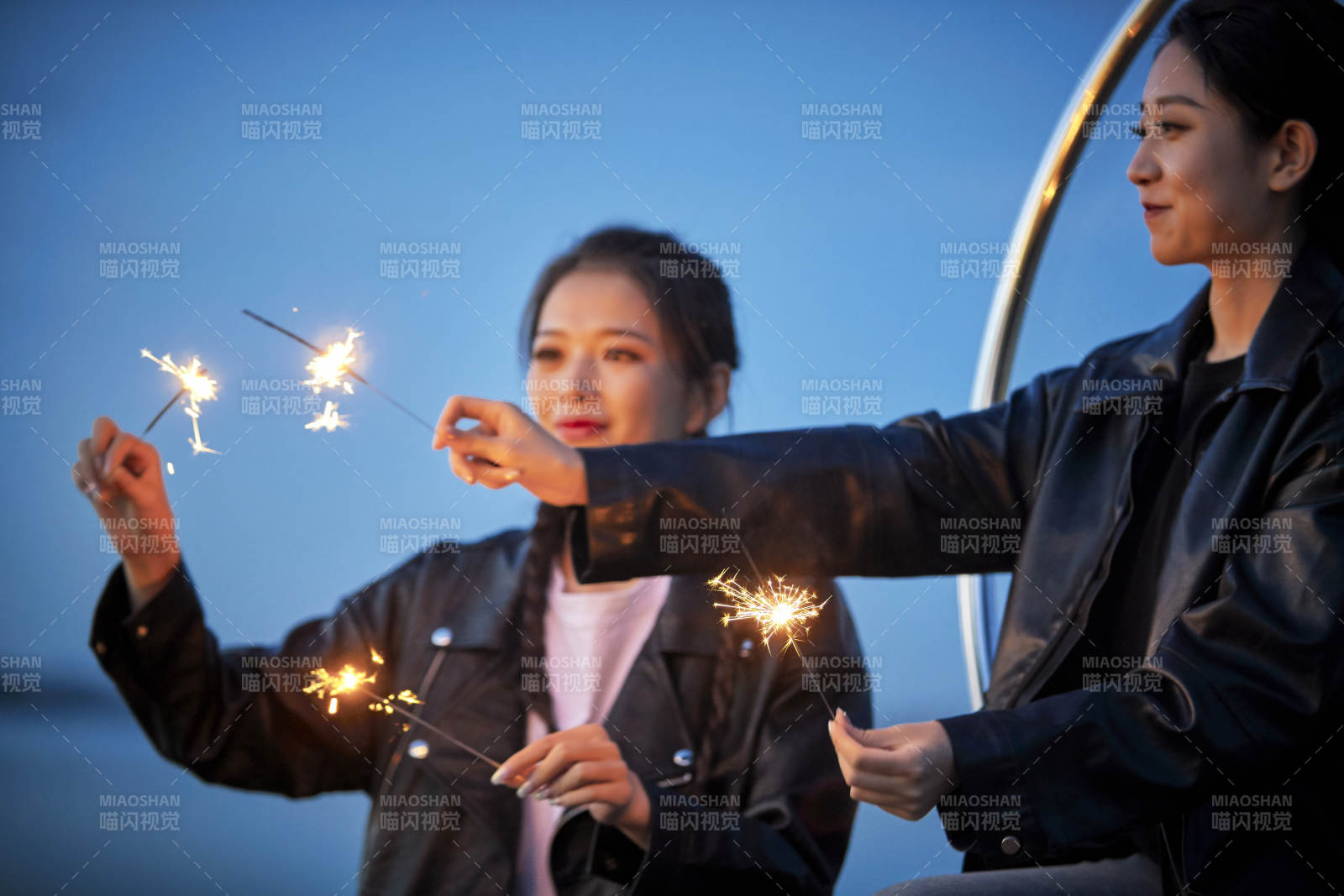傍晚湖畔透明秋千上燃放仙女棒的可爱少女