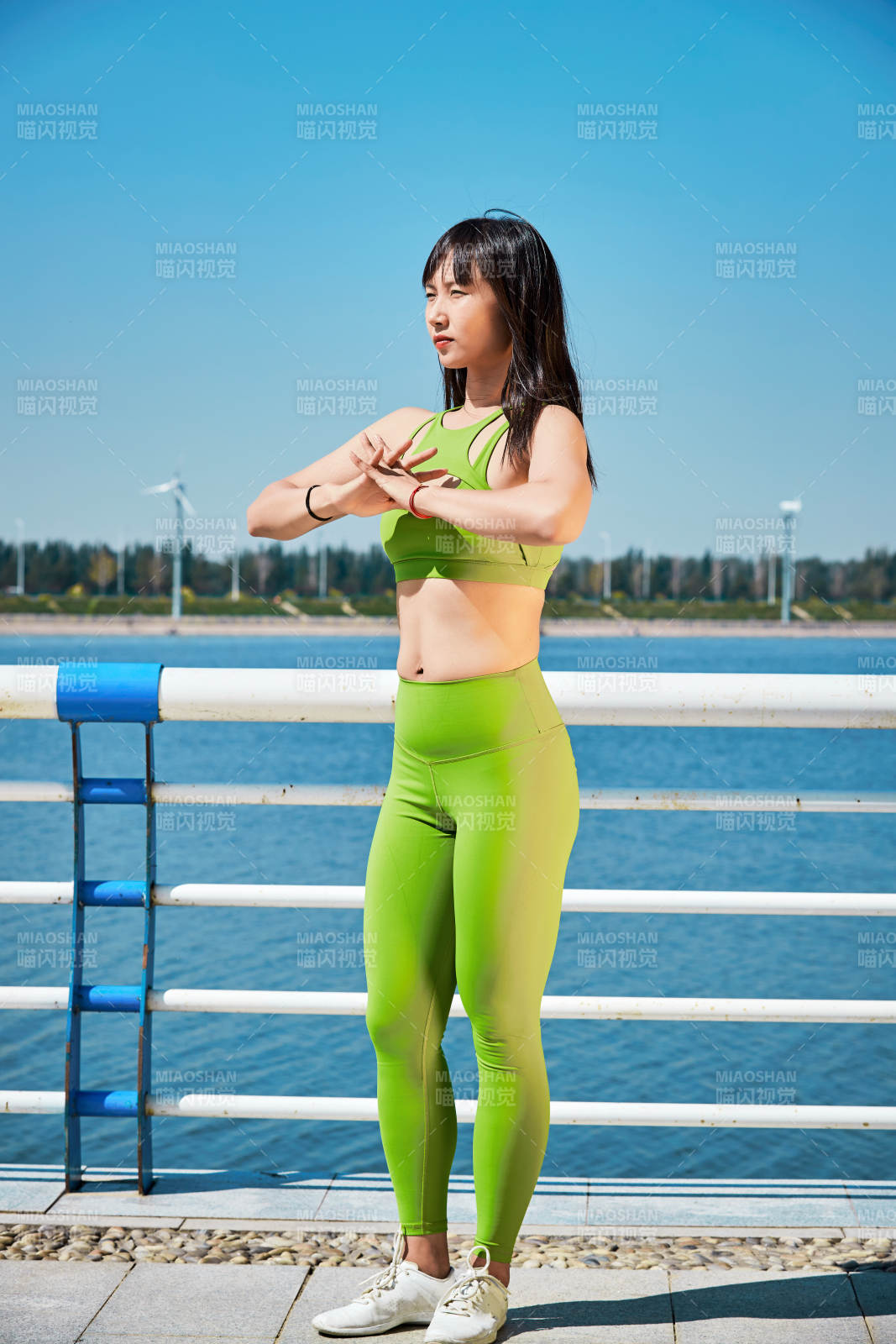 戶外河畔公園做拉伸有氧運動的亞洲女性