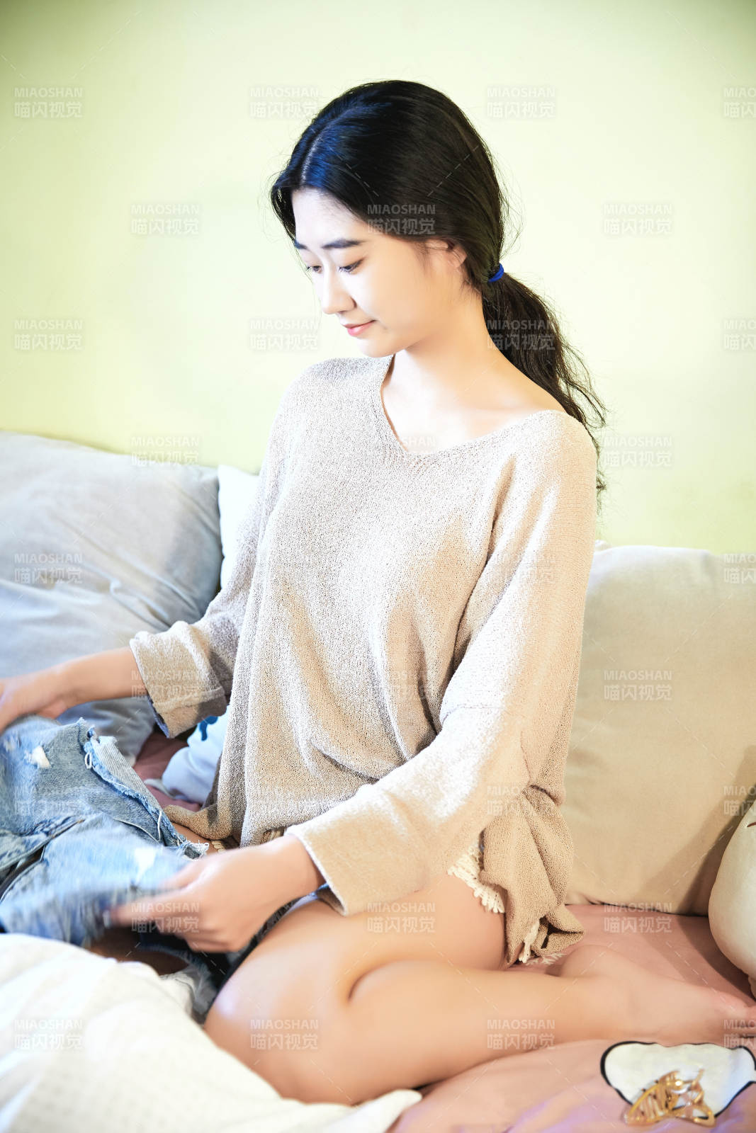 在沙發床上整理行裝的年輕亞洲女性