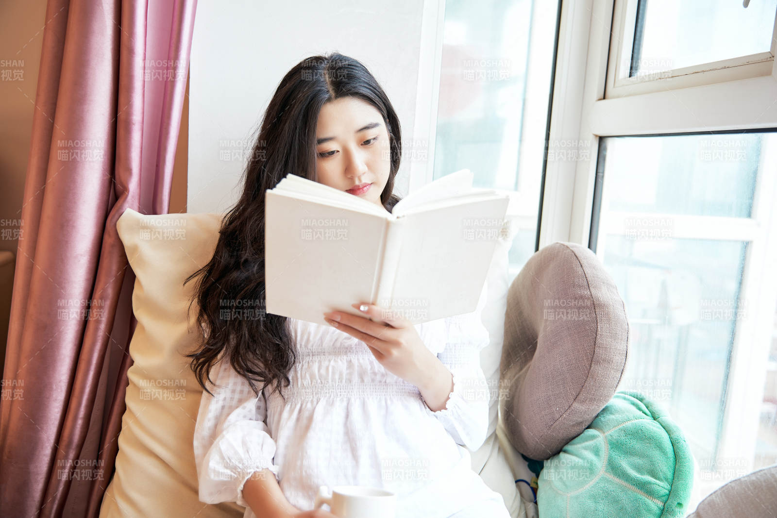 躺在舒適的飄窗上看書的女孩