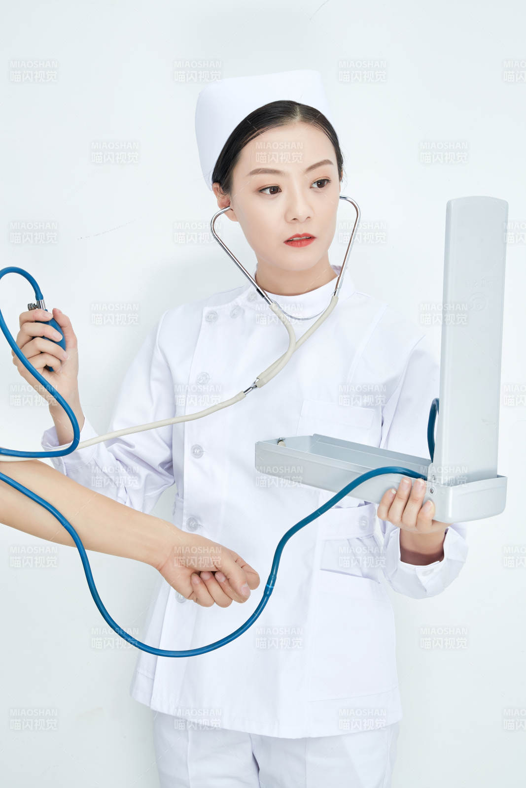 白色背景下手持血壓計測量血壓的醫生