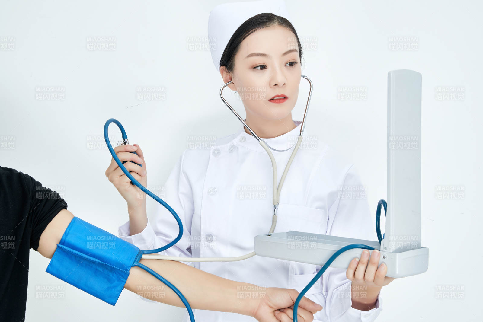 白色背景下手持血壓計測量血壓的醫生