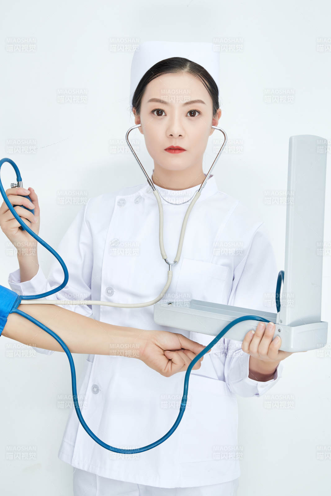 白色背景下手持血壓計測量血壓的醫生