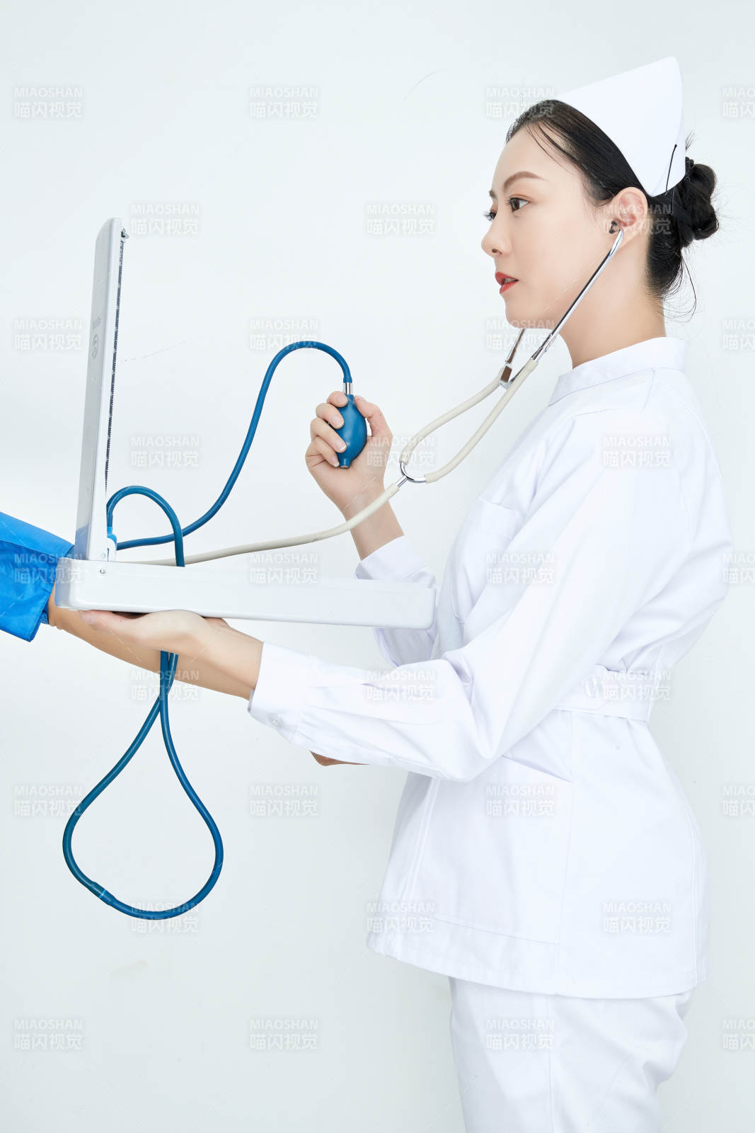 白色背景下手持血壓計測量血壓的醫生