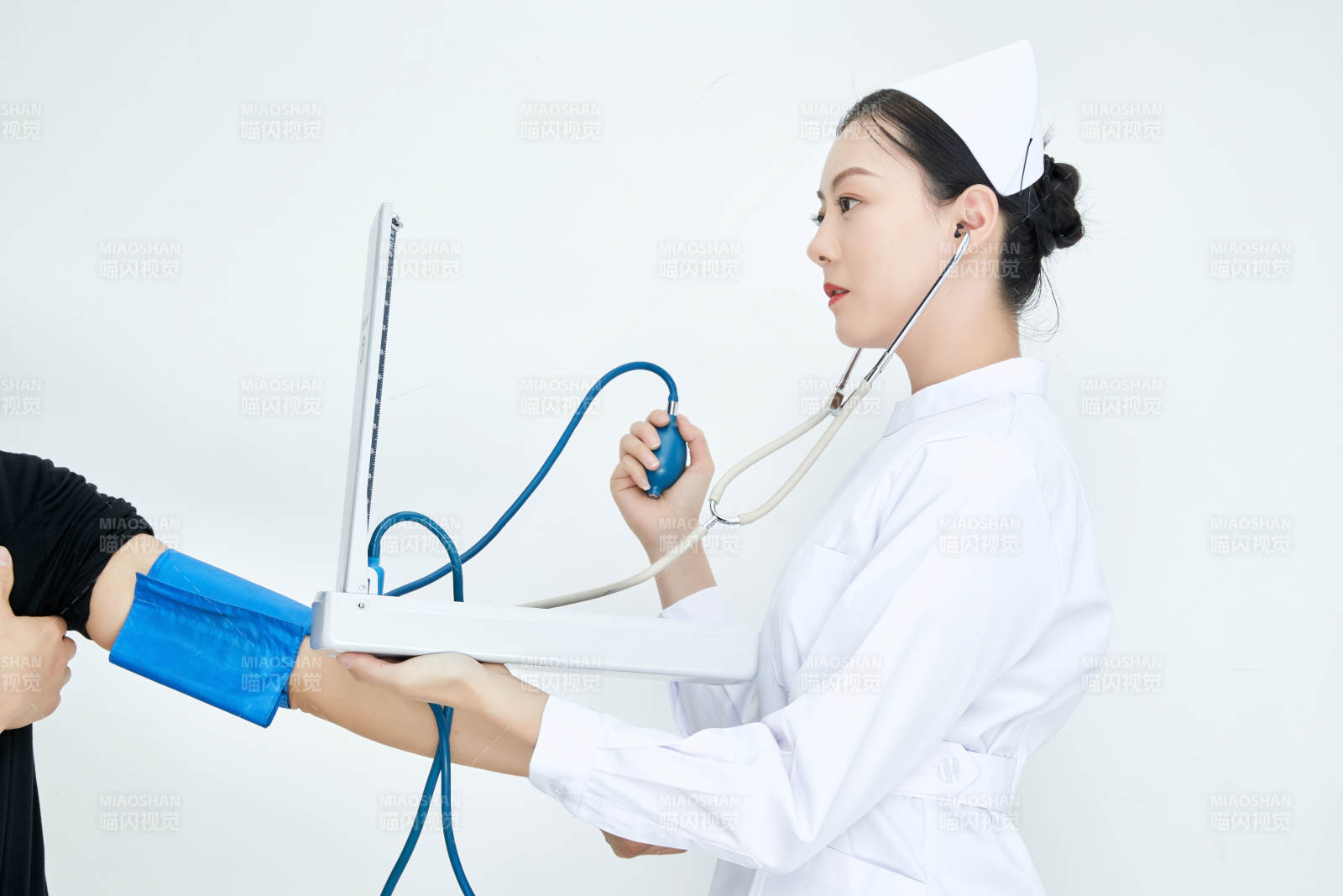 白色背景下手持血壓計測量血壓的醫生