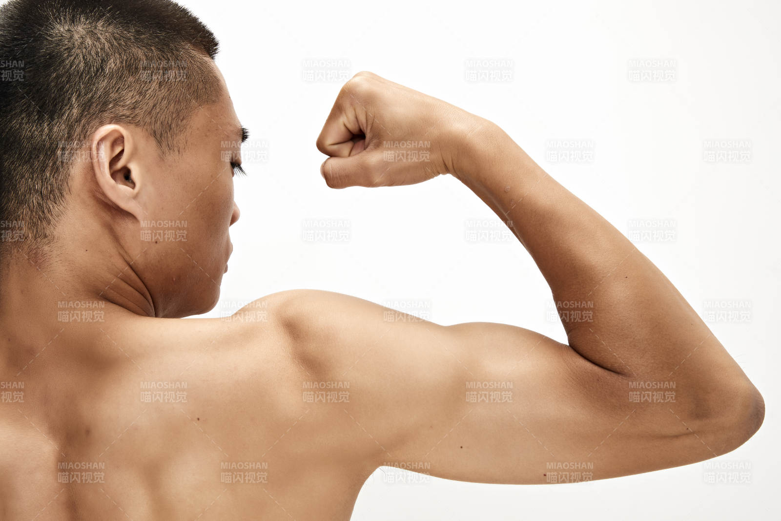 白色背景下展示肱二頭肌的亞洲健身男性