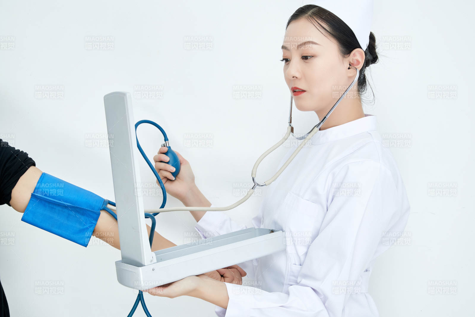 白色背景下手持血壓計測量血壓的醫生