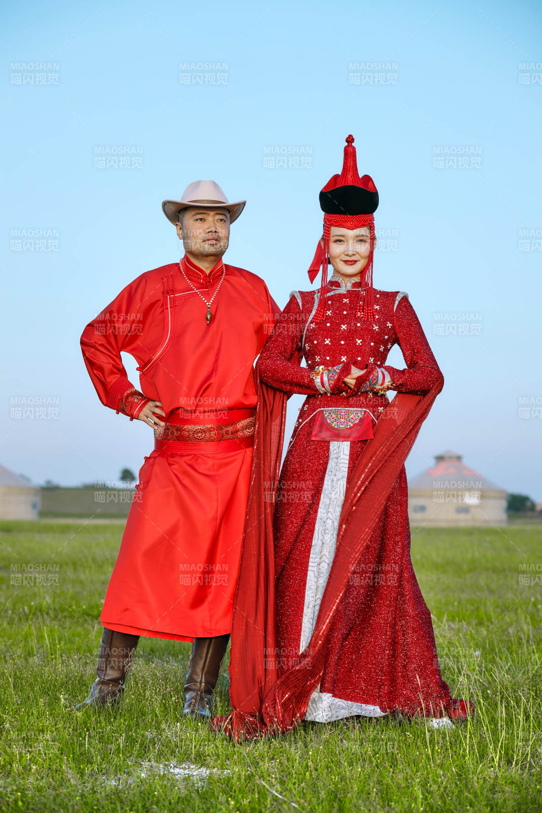 草原上蒙古包前穿蒙古族传统服饰的年轻夫妻