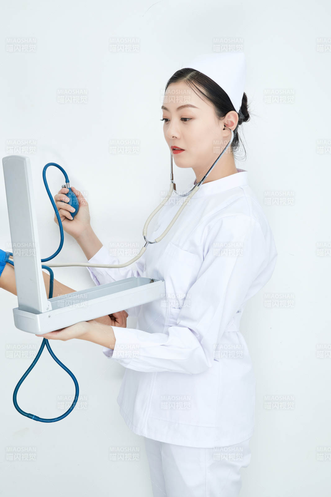 白色背景下手持血壓計測量血壓的醫生