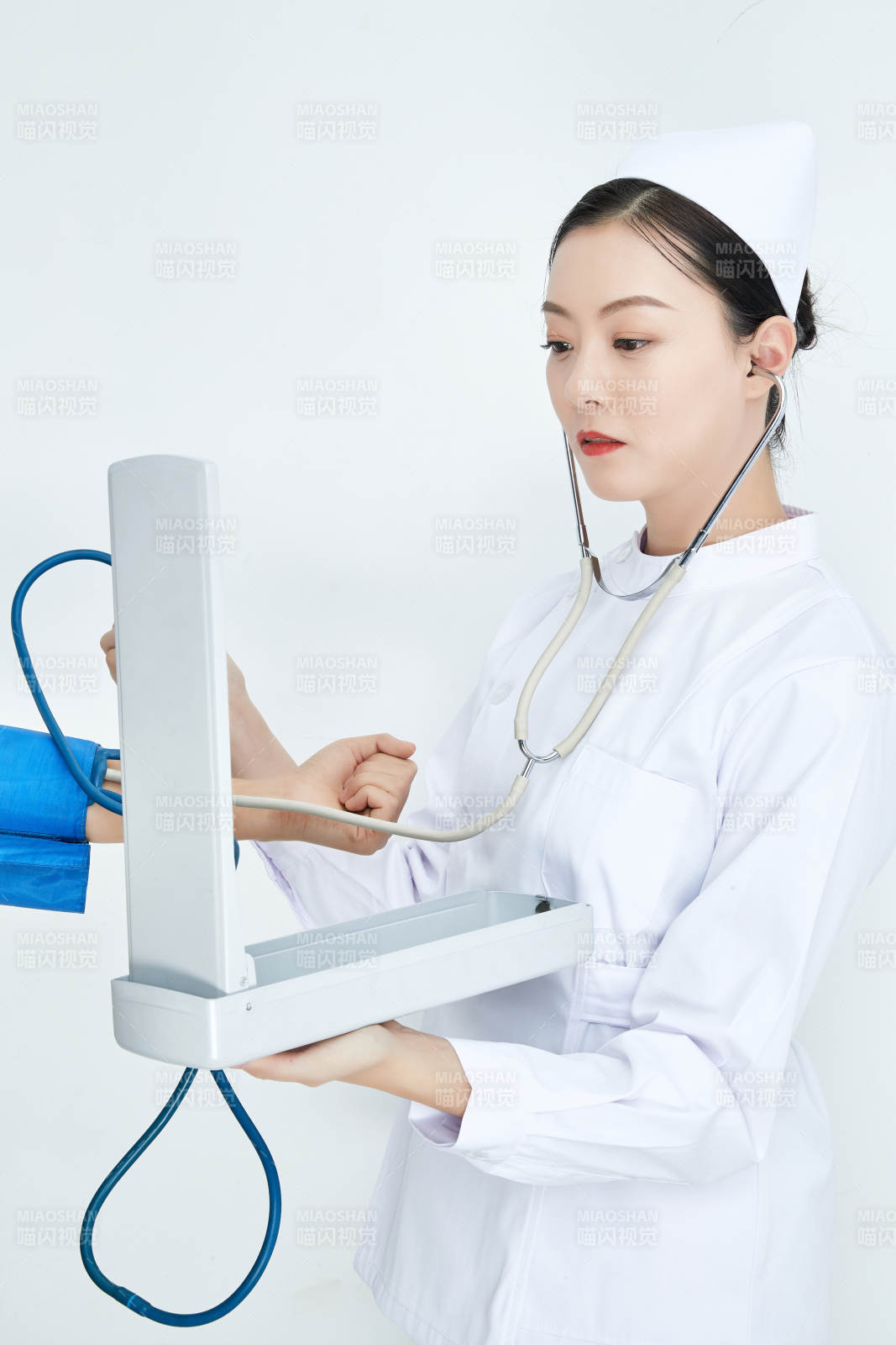 白色背景下手持血壓計測量血壓的醫生