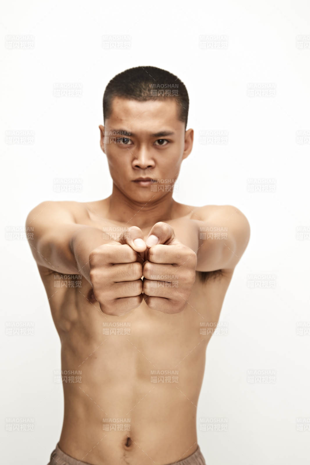 白色背景下演示自由搏擊動(dòng)作的亞洲功夫男性
