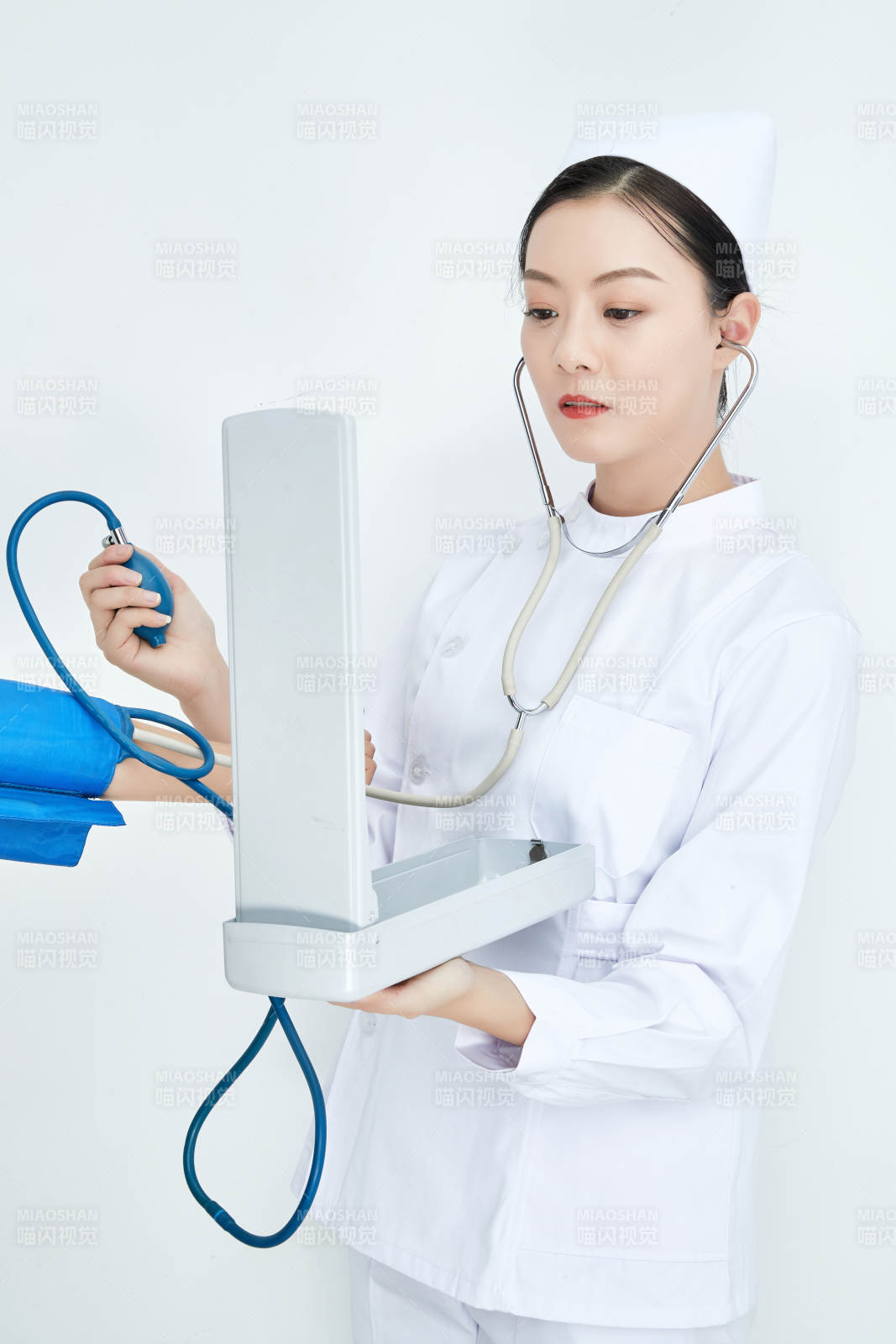 白色背景下手持血壓計測量血壓的醫生