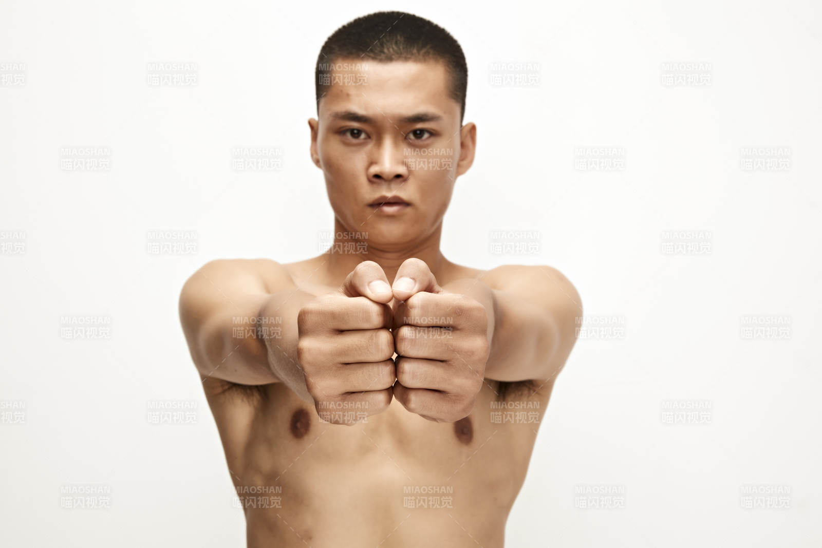 白色背景下演示自由搏擊動(dòng)作的亞洲功夫男性