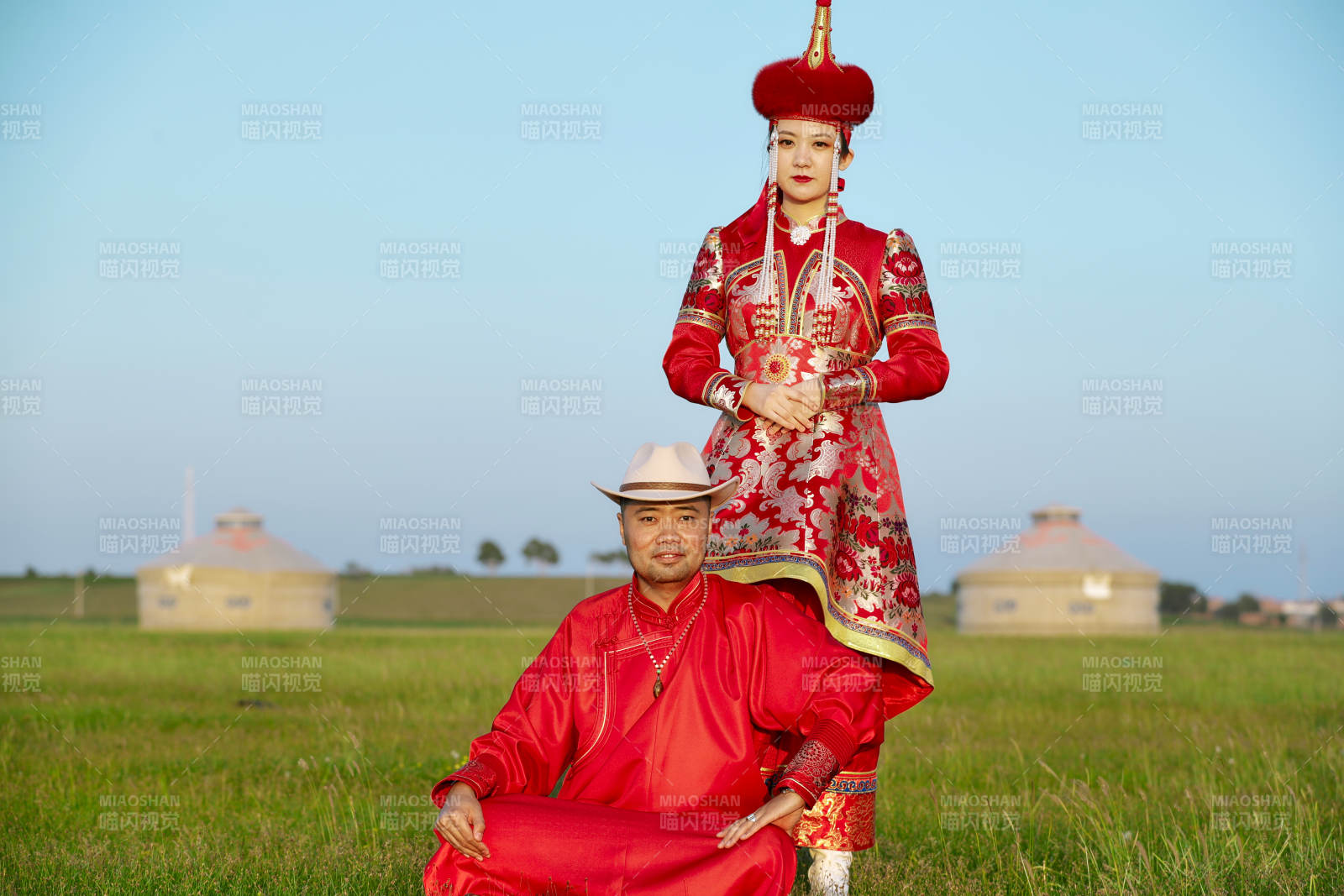 草原上蒙古包前穿蒙古族傳統服飾的年輕夫妻