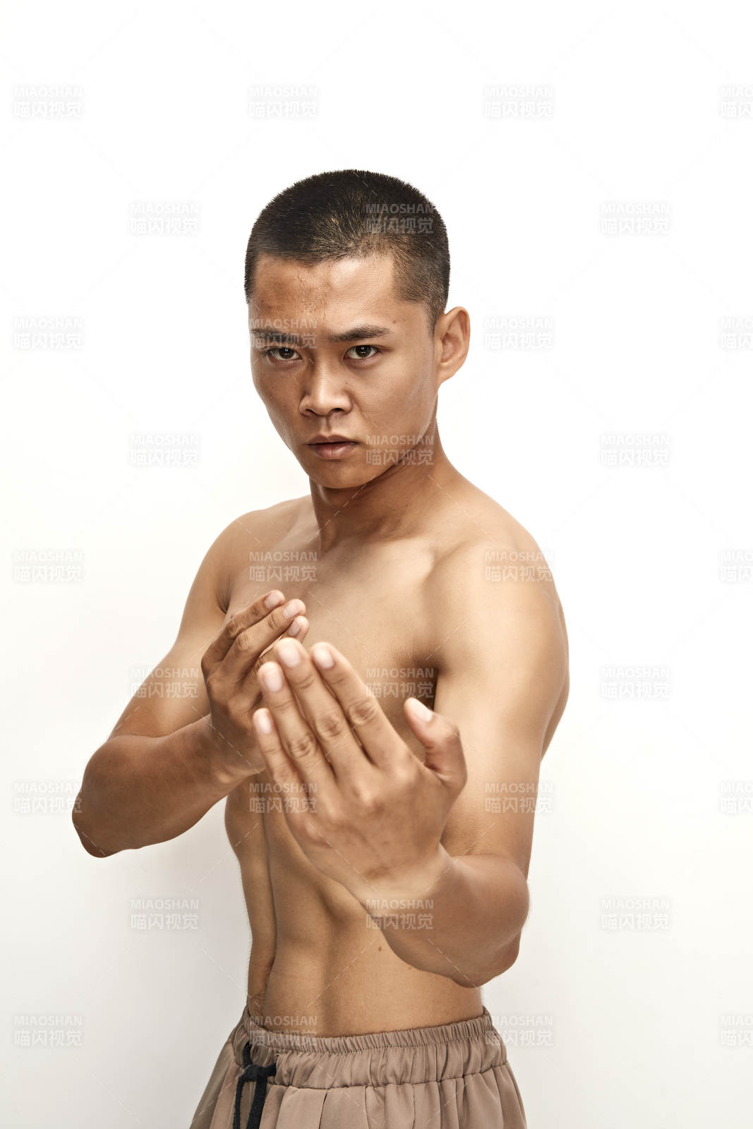 白色背景下演示自由搏擊動作的亞洲功夫男性