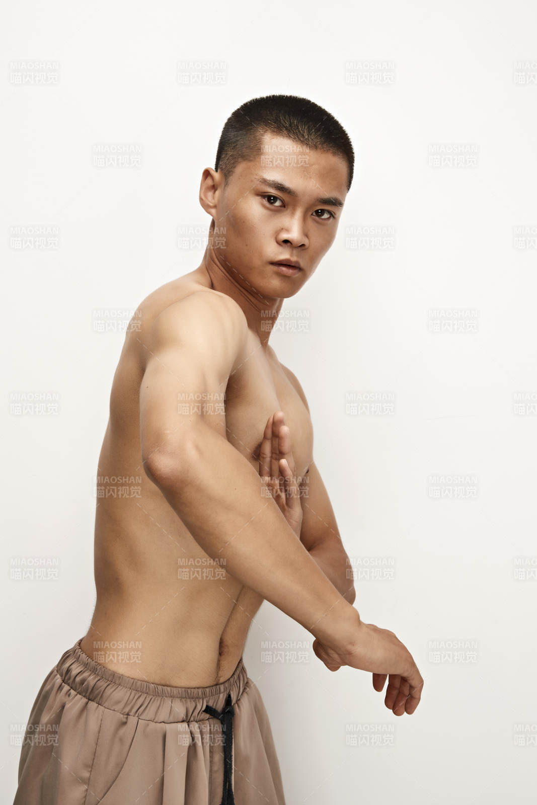 白色背景下演示自由搏擊動(dòng)作的亞洲功夫男性