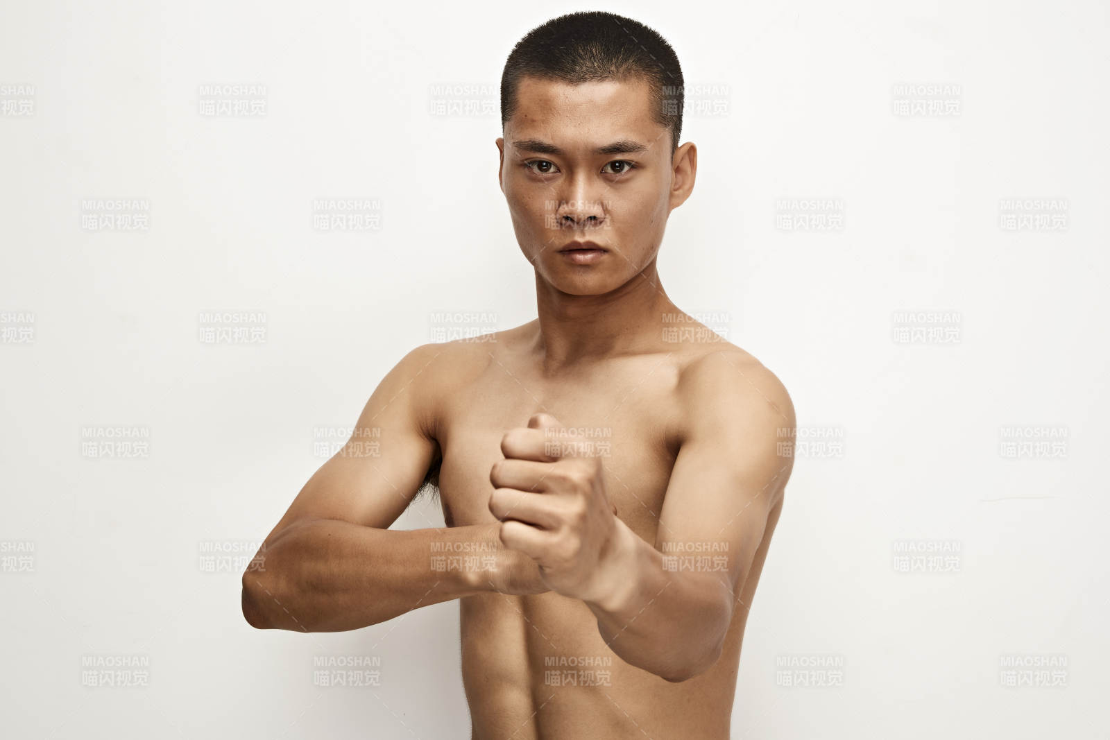 白色背景下演示自由搏擊動作的亞洲功夫男性