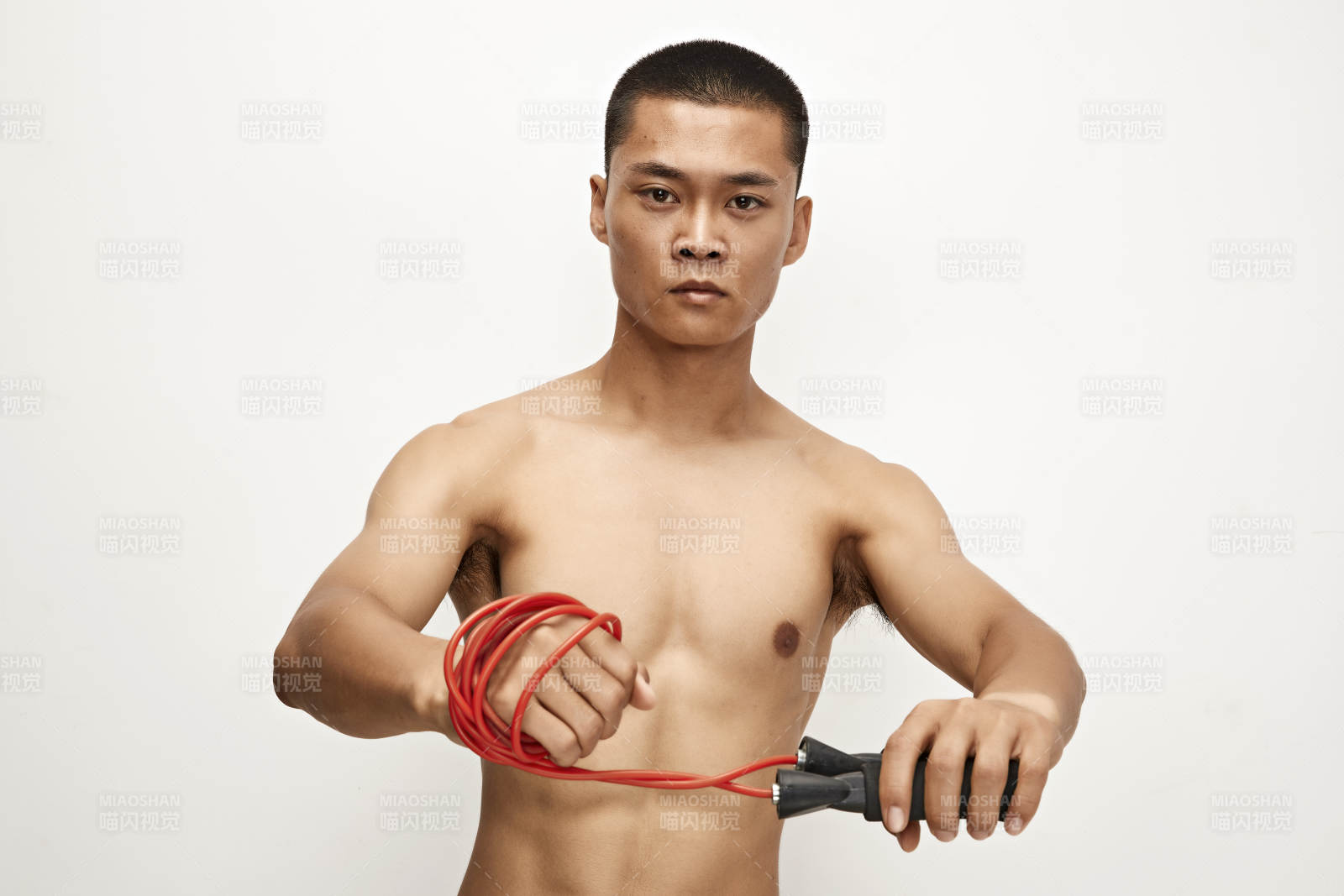 白色背景下手持运动跳绳的亚洲健身男士形象